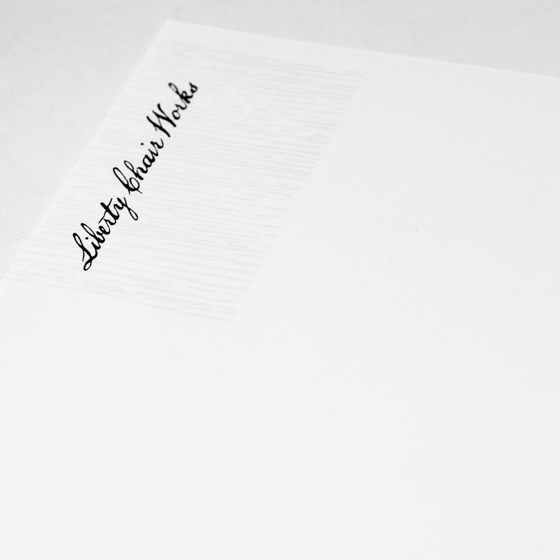 Liberty Chair Works letterhead detail of logo and woodgrain.